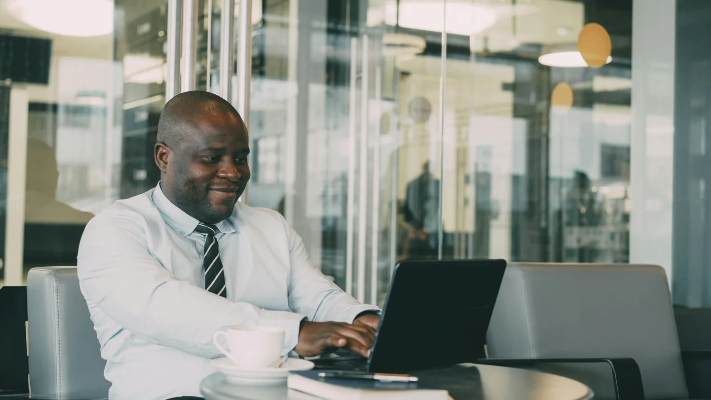 A professional working on a laptop in a bright office